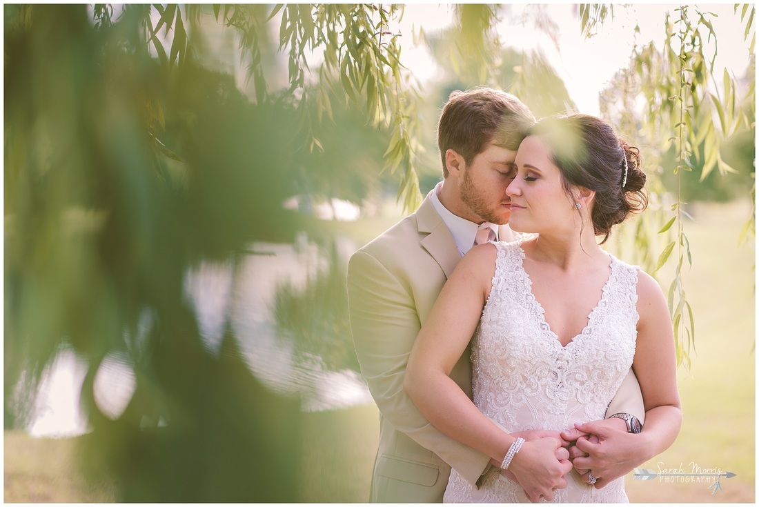 Formal bridal portraits of the bride and groom under a weeping willow tree at Bellevue Baptist Church