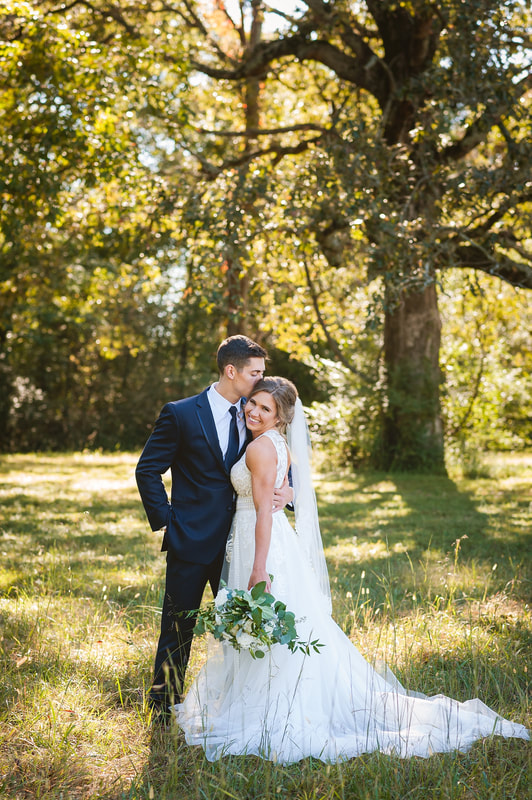 Groom hugging bride close and kissing her cheek during wedding portraits in Collierville, TN with Sarah Morris Photography