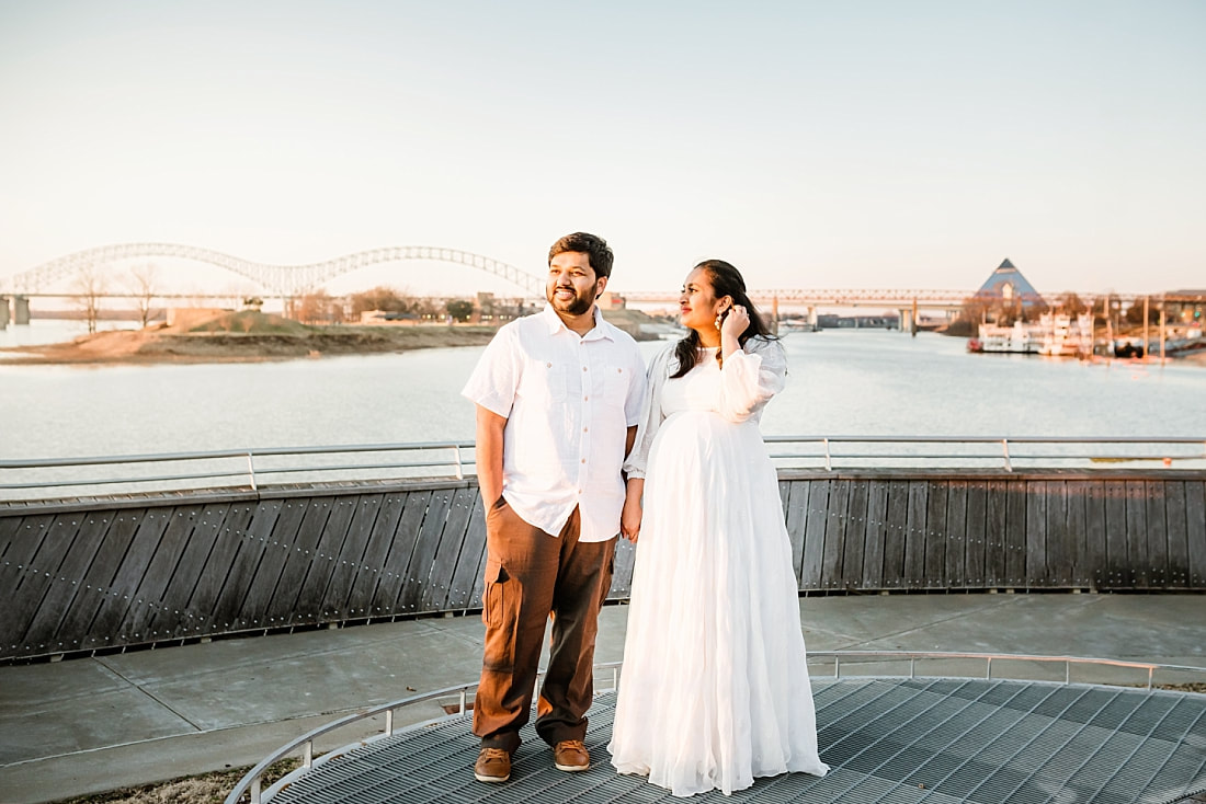 husband and wife hold hands by the mississippi river downtown memphis