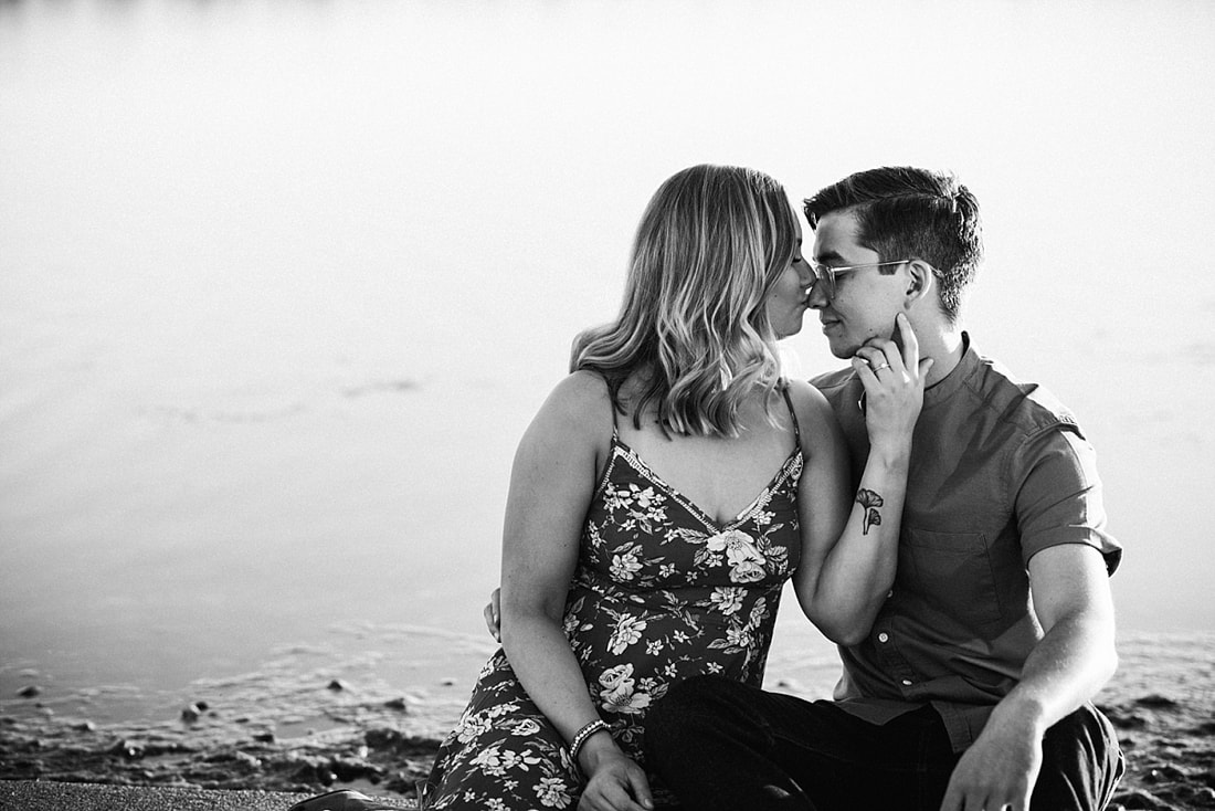 couple posing for engagement photos by the lake at shelby farms park in memphis, tn