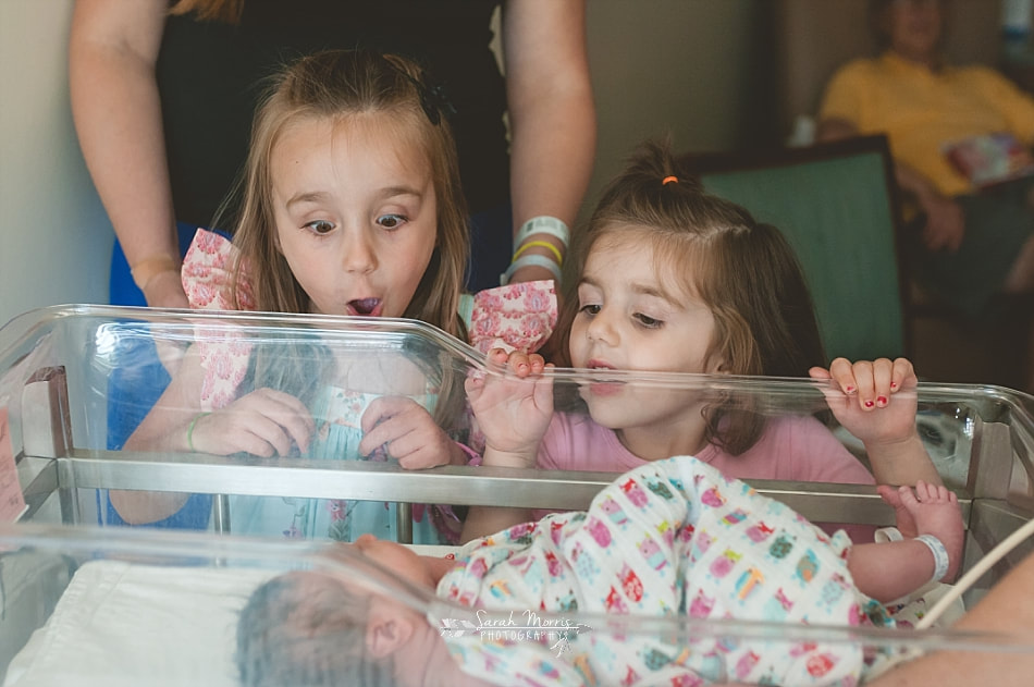 big sisters are amazed when looking at their newborn baby sister at Methodist Le Bonheur Germantown Hospital