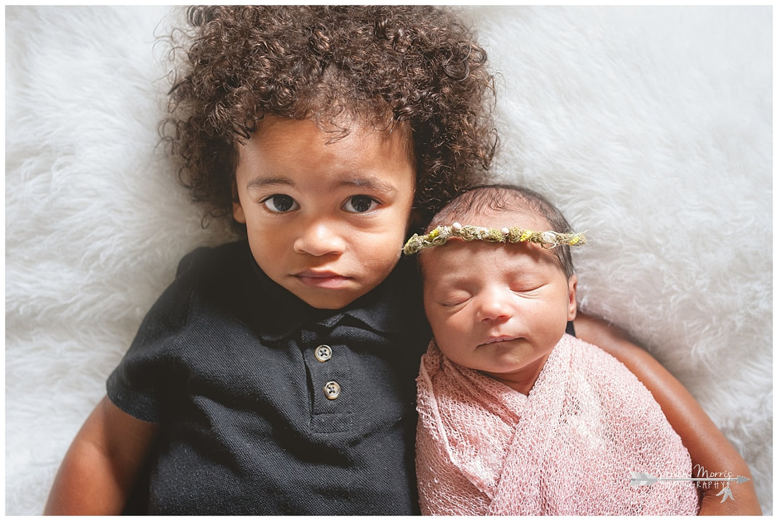 newborn photos with toddler sibling on white fur