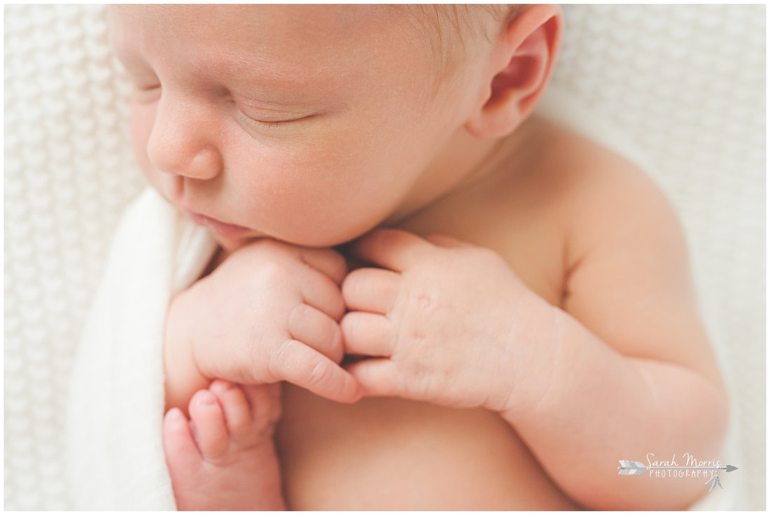 Close up Newborn photo of baby boy sleeping on white blanket