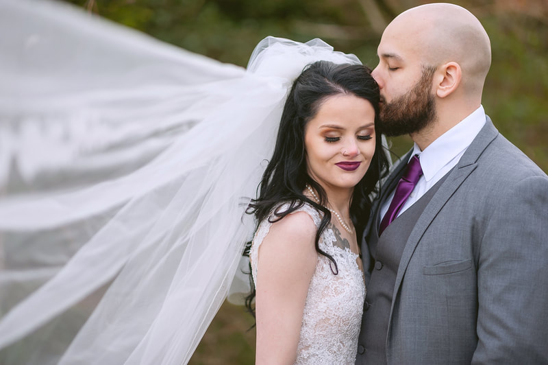 Groom kissing bride's forehead during bridal portraits outside of Overton Chapel Memphis, TN