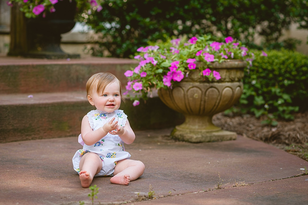 baby girl's first birthday portrait in monogrammed bubble on the front porch during in home lifestyle family session in collierville, tn