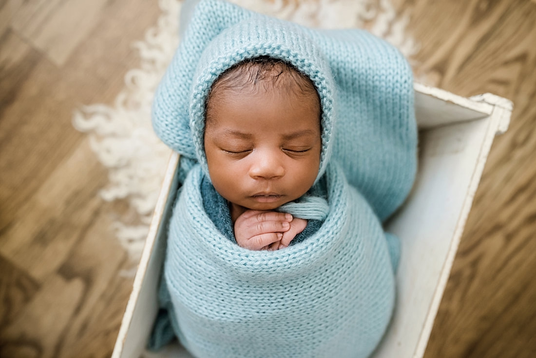 newborn baby wrapped in blue in wooden box for newborn session in Memphis, TN