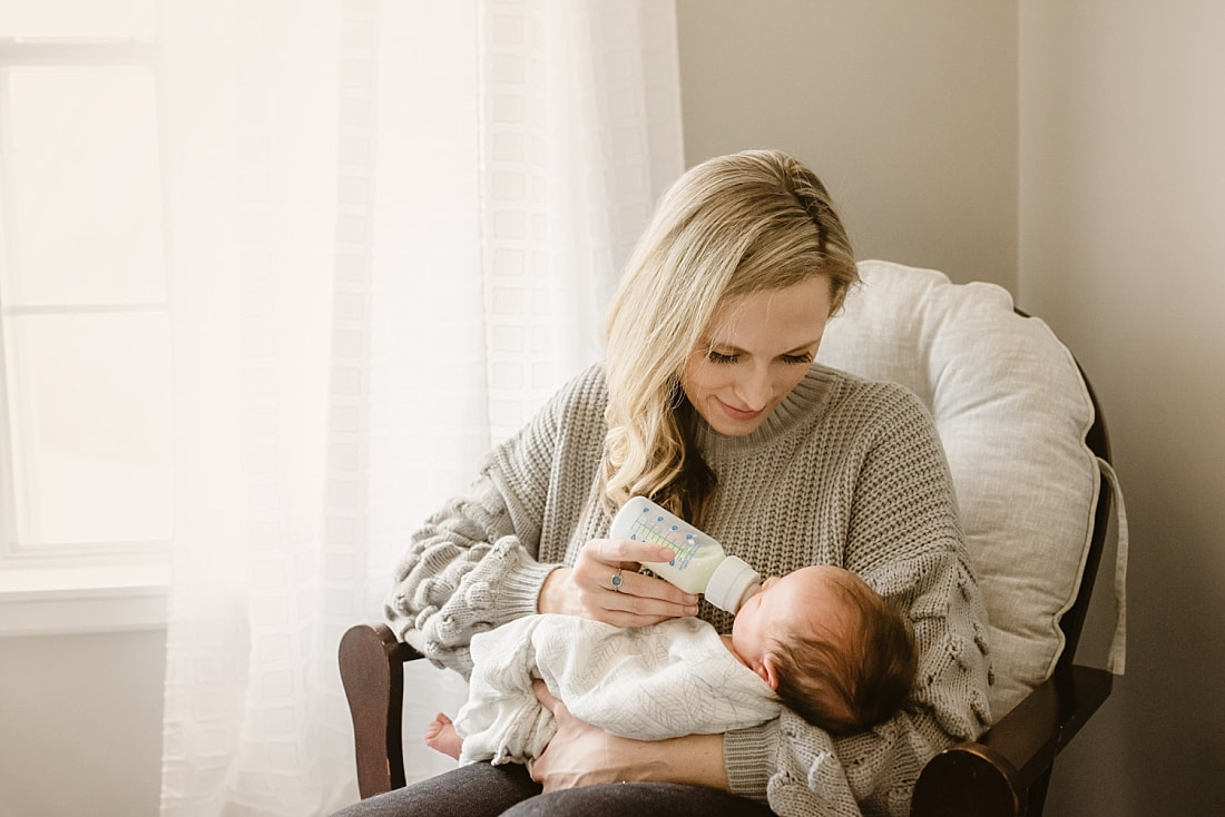 Mother feeding baby in nursery 