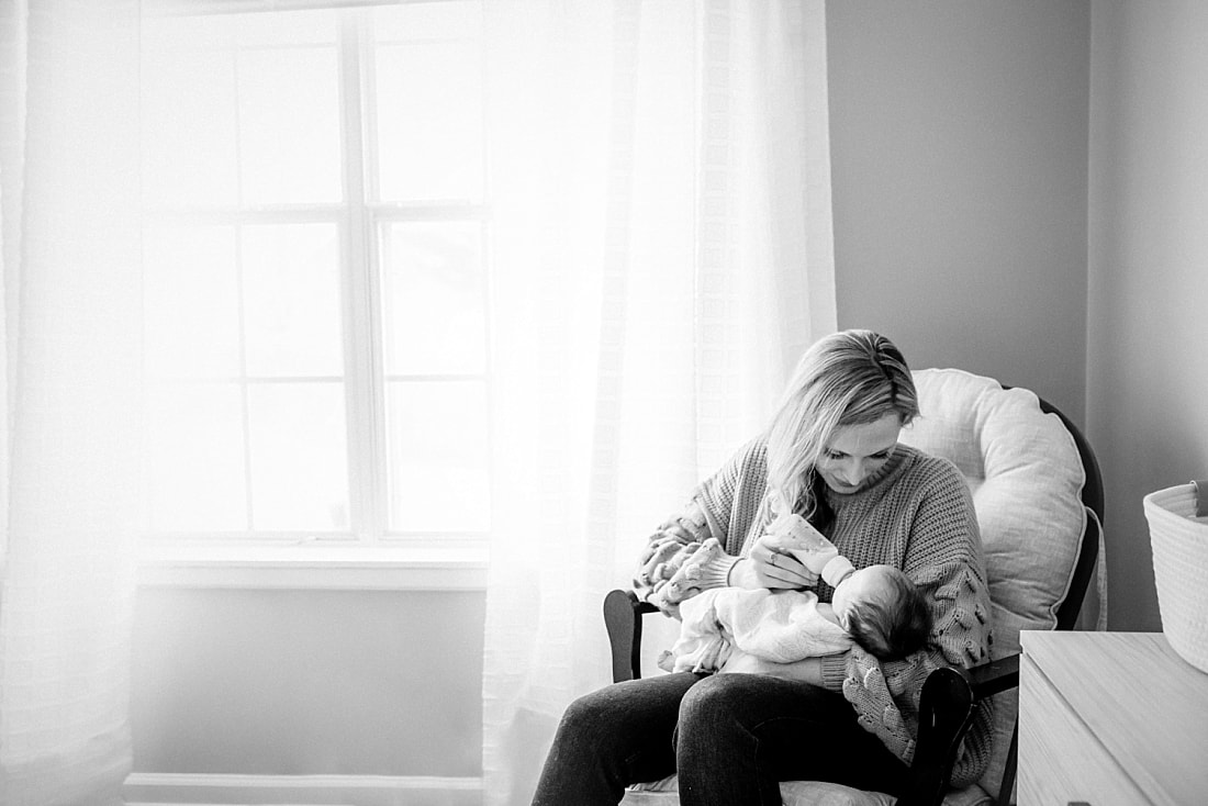 Mother feeding baby in nursery 