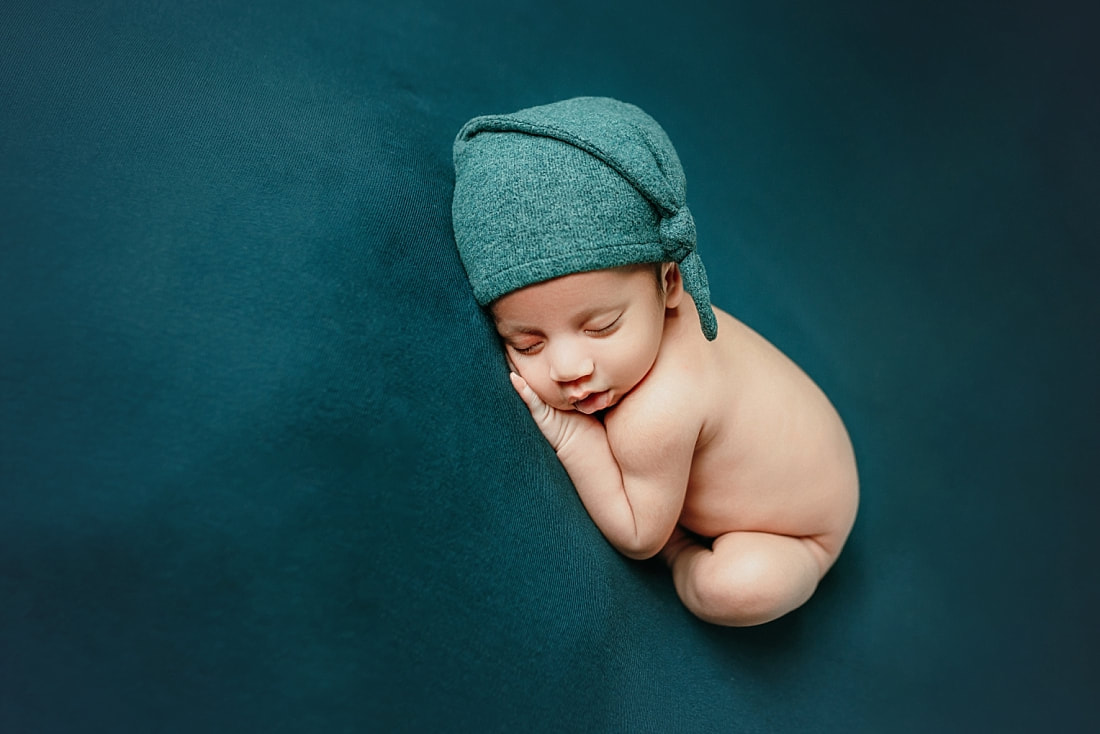 newborn baby boy posed on teal blanket for newborn photoshoot in Memphis, TN