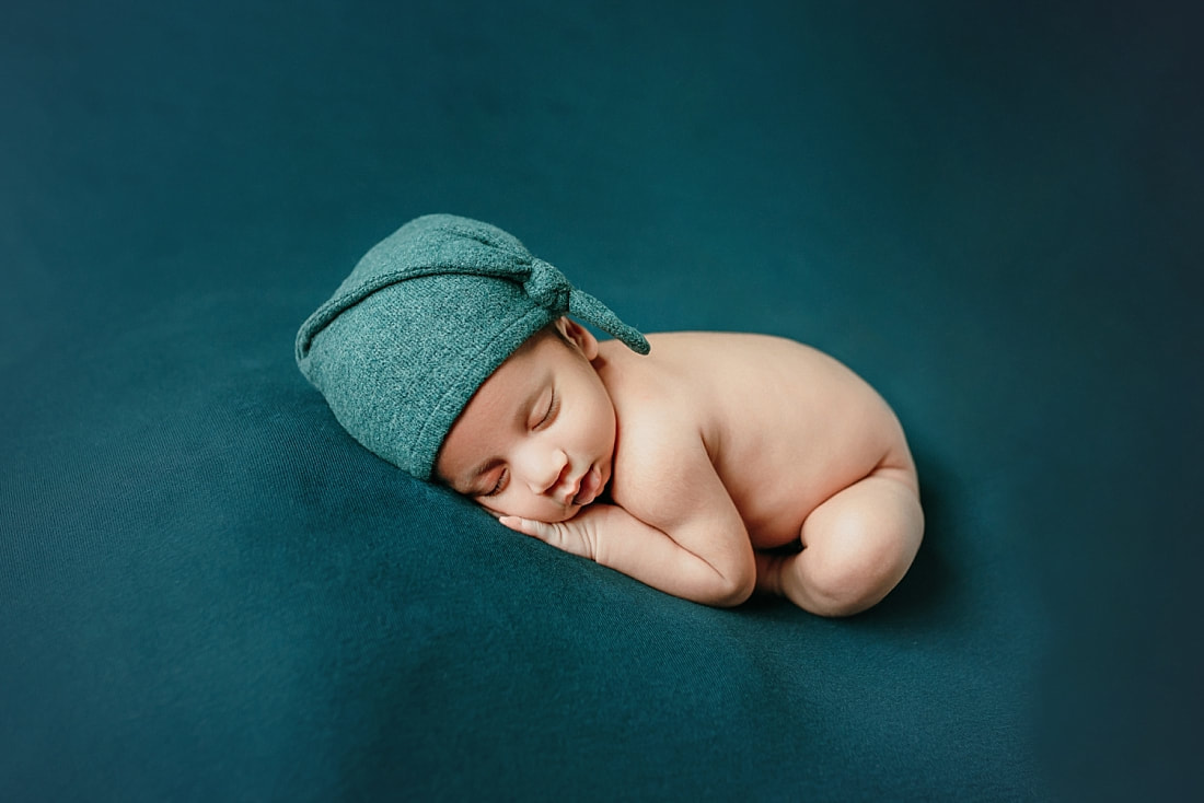 newborn baby boy posed on teal blanket for newborn photoshoot in Memphis, TN