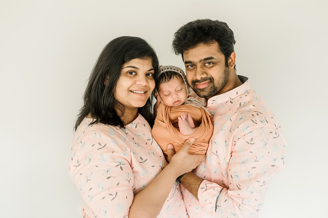 parents holding swaddled newborn baby in Memphis, TN