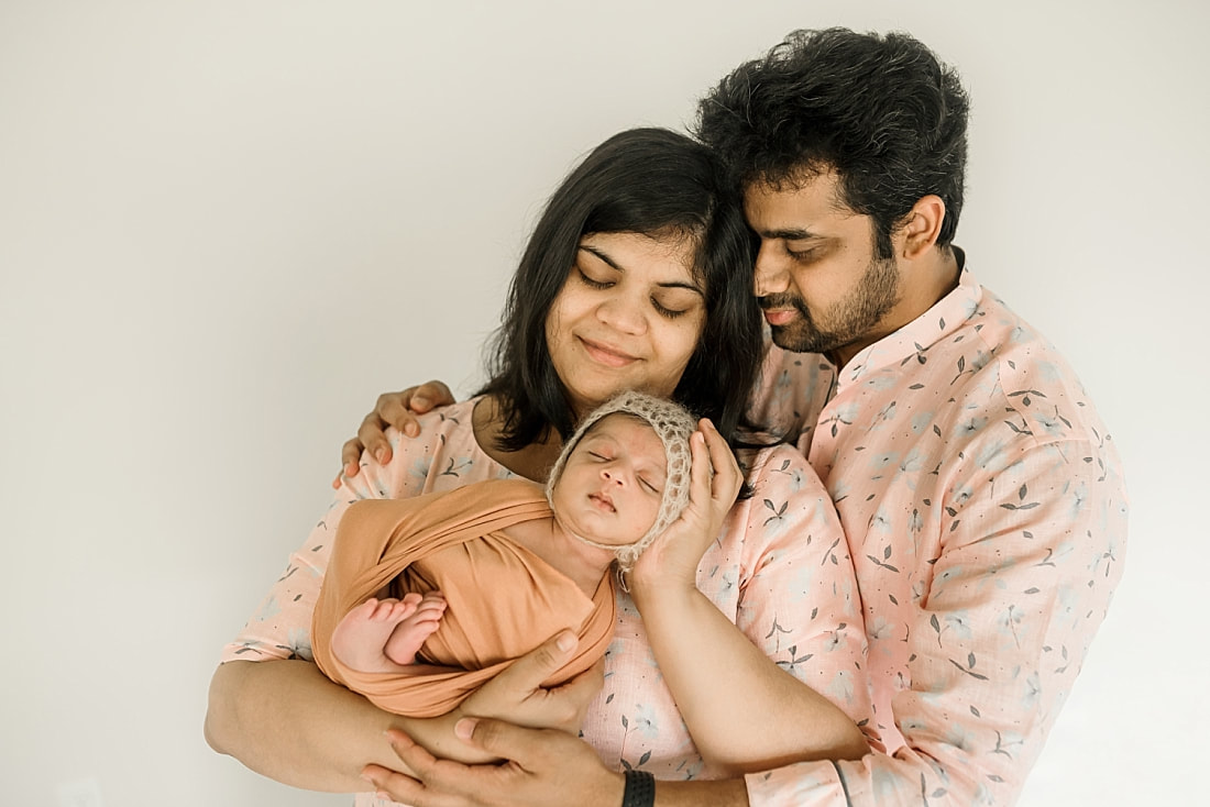 parents holding swaddled newborn baby in Memphis, TN