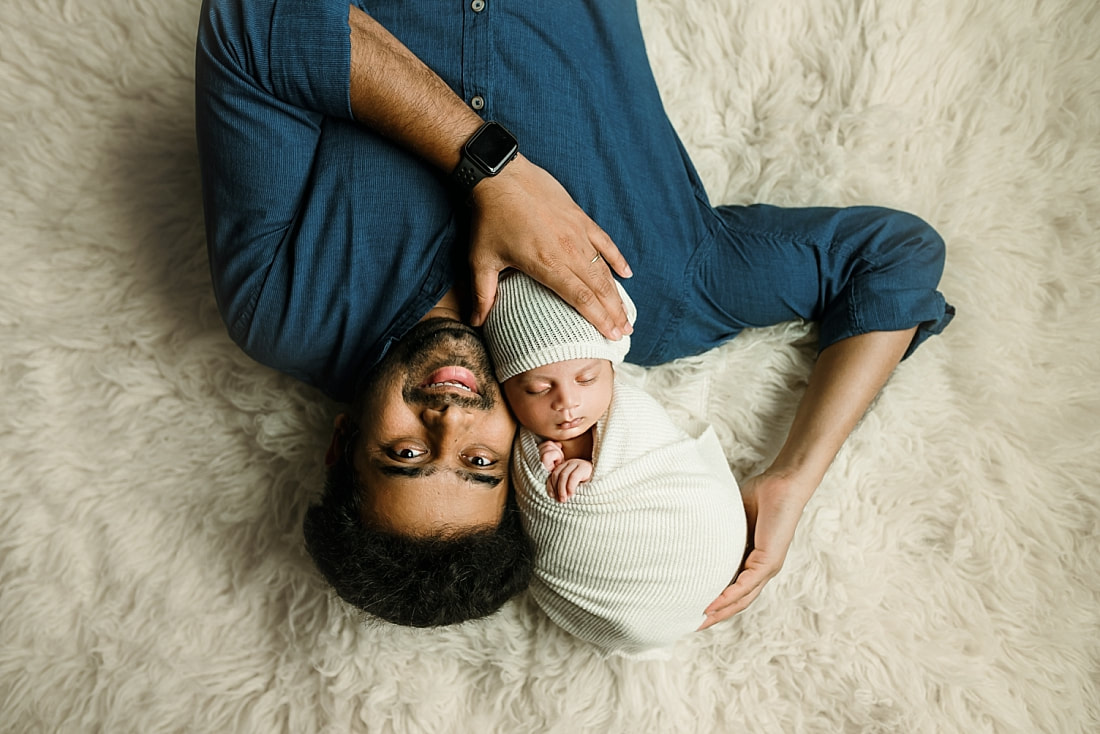 Newborn baby boy swaddled held by dad for newborn portrait in Memphis, TN