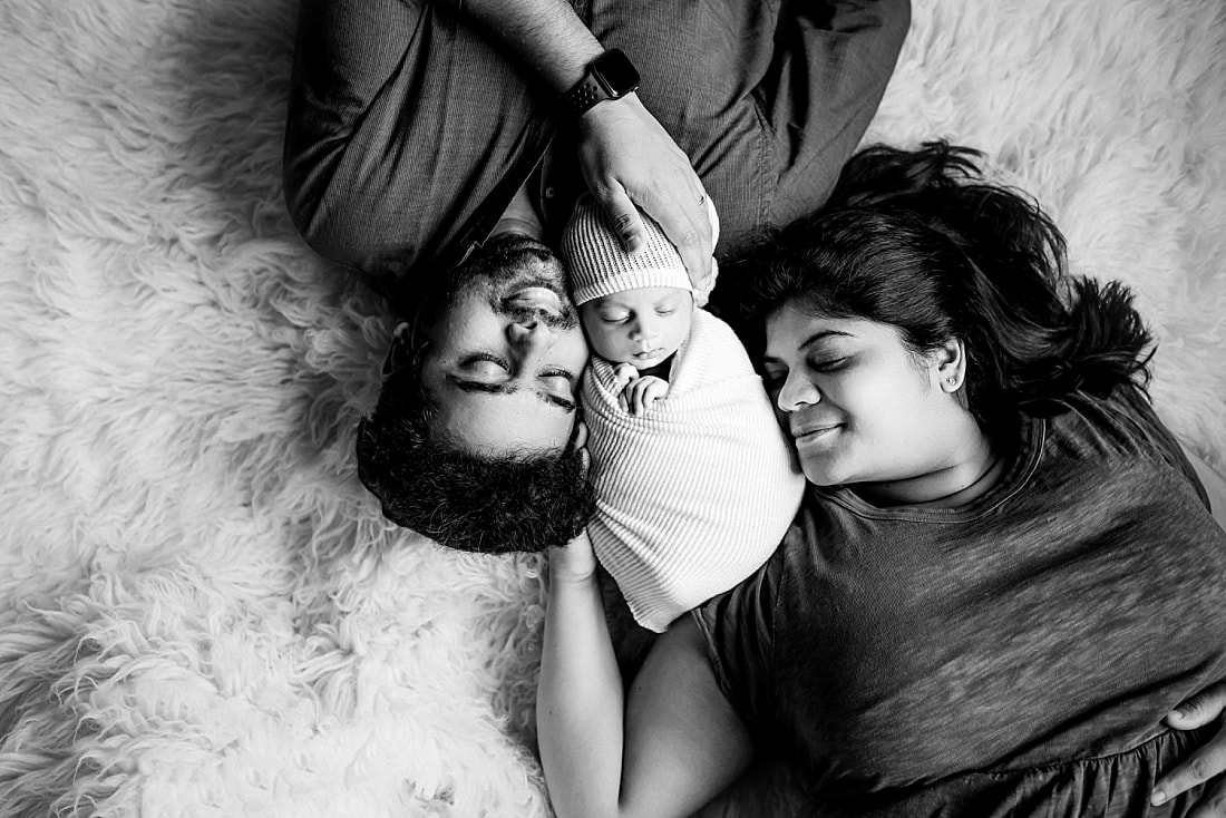 Newborn baby boy swaddled with parents for newborn portrait in Memphis, TN