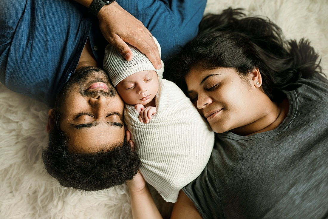 Newborn baby boy swaddled with parents for newborn portrait in Memphis, TN