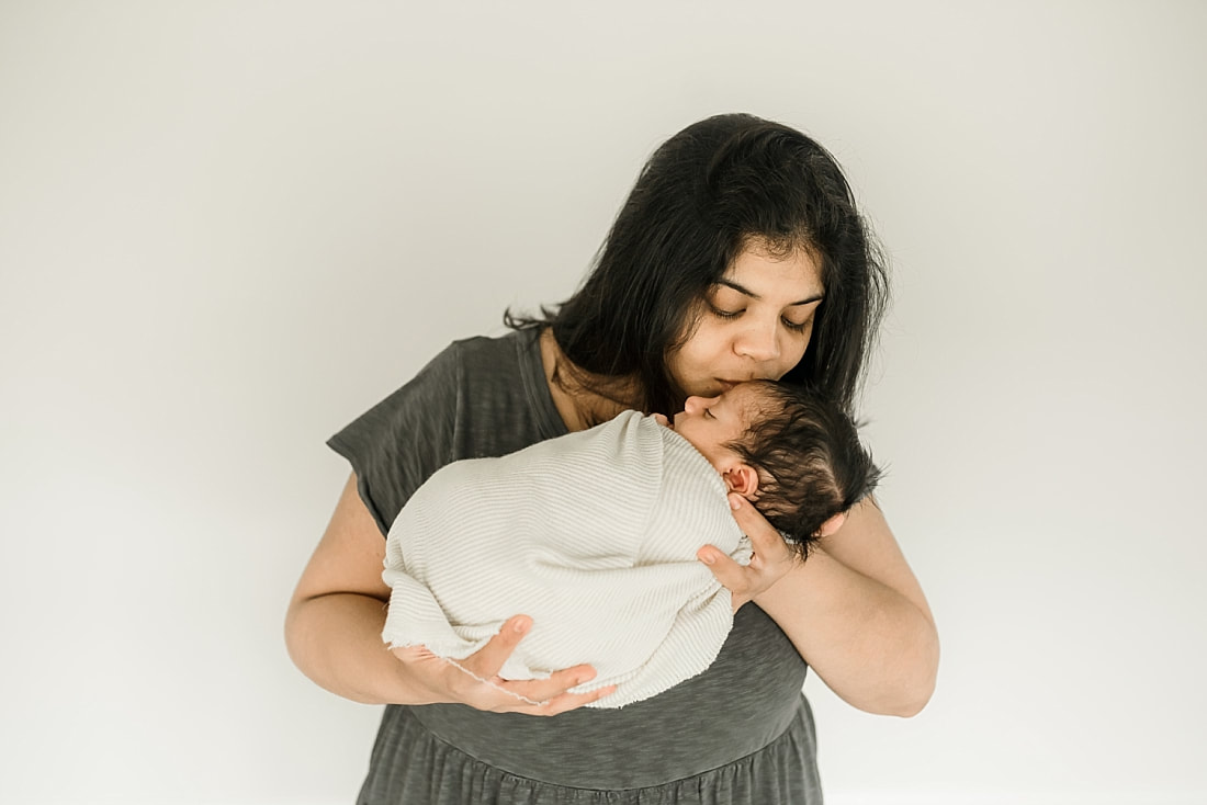 mom holding swaddled newborn baby in Memphis, TN