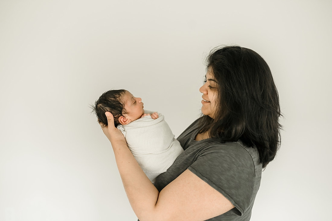 mom holding swaddled newborn baby in Memphis, TN