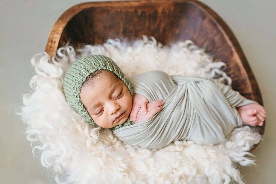 baby boy wearing knit green bonnet during newborn photo session in memphis