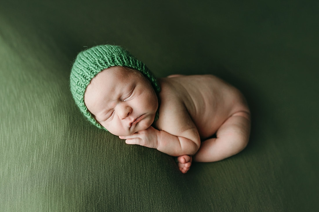 newborn baby boy posed and sleeping on green blanket in Memphis, TN