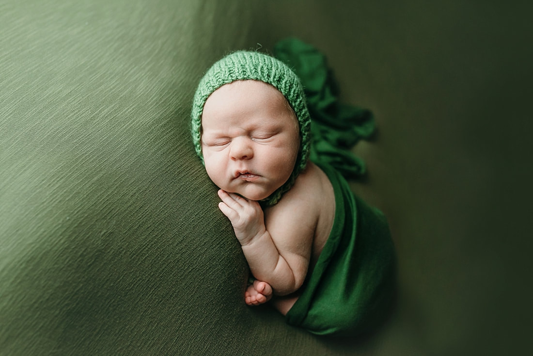 newborn baby boy posed and sleeping on green blanket in Memphis, TN