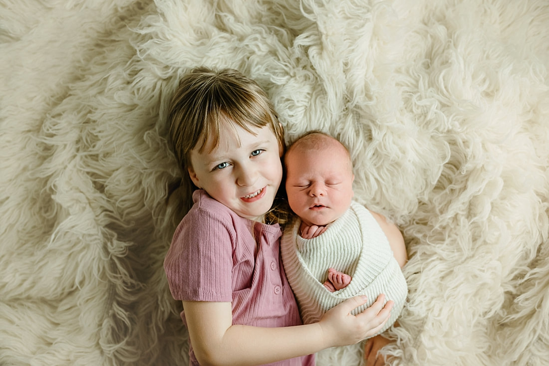 big sister holding newborn baby brother in Memphis, TN