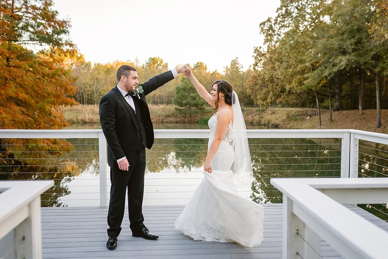 Groom twirling bride in her wedding dress on the dock at Orion Hill + Memphis, TN wedding