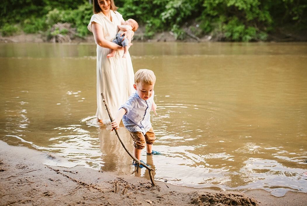 child playing with a stick in the sand at the Wolf River in Memphis, TN