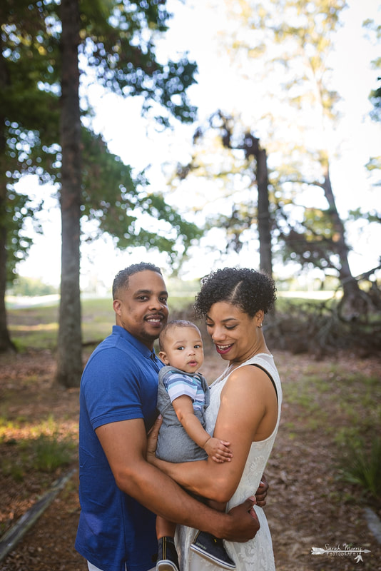 Family cuddled up in the woods at Shelby Farms Park