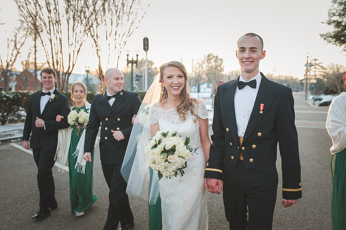 Bride and groom walking through the Collierville Town Square with their bridal party